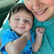 Greyson joined the competition — help win amazing prizes! baby, woman, smile, face, portrait, child, car_interior, blue_shirt, cartoon_character, holding, closeup, happy, cute, casual_clothing, skin, person, arm, window, hair, nose_ring