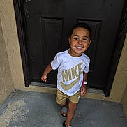 Adriel is registered to the contest to win money with this photo: child, toddler, smile, happy, nike, tshirt, shorts, sandals, door, concrete, outdoor, person, footwear, clothing, walking, young, cute, skin, face, casual