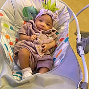 Eevee is registered to the contest to win money with this photo: baby, baby_bouncer, bow, child, colorful, comfort, cozy, cute, fabric, headband, indoors, infant, looking_at_camera, playtime, portrait, purple_outfit, seated, smiling, socks, toy