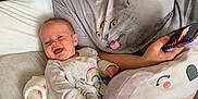 Ivy joined the competition — help win amazing prizes! baby, bed, blanket, casual, cat_graphic, child, clothing, cozy, cute, happy, indoor, lying_down, person, phone, pillow, relaxing, smiling, tshirt, unicorn, woman