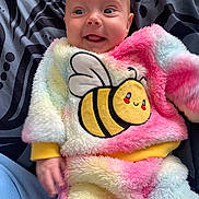 Ivy joined the competition — help win amazing prizes! adorable, baby, bee_patch, blanket, blue_eyes, child, colorful, cozy, cute, fluffy_clothing, happy, infant, lying_down, patterned_background, portrait, smiling, soft_texture, tongue_out, warm_clothing, young_child
