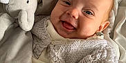 Ivy joined the competition — help win amazing prizes! baby, smiling, knitted_sweater, plush_toy, elephant_toy, blanket, cozy, happy, infant, soft_toy, cute, child, portrait, warm, indoors, closeup, person, fabric, comfort, sleepwear