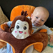 Mael participe au concours pour gagner de l'argent avec cette photo : baby, infant, plush_seat, smile, blue_clothing, face, child, indoor, couch, blanket, pacifier, toy, soft_toy, cute, happy, sitting, head, hand, furniture, home