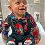 Mael a rejoint le concours — aidez-le/la à gagner de superbes lots ! baby, child, smiling, plaid_shirt, bow_tie, suspenders, festive_pants, santa_claus, shoes, socks, indoor, tiled_wall, happy, cute, portrait, seated, infant, clothing, footwear, face