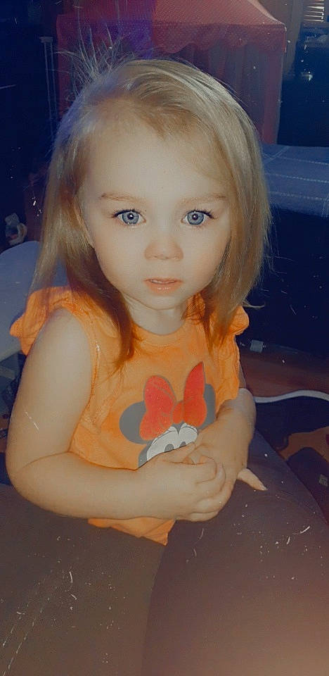 Lyla is registered to the contest to win money with this photo: arm, bangs, cheek, child, chin, doll, ear, eyebrow, eyelash, fawn, happy, iris, lip, long_hair, mouth, nose, person, pink, skin, toy