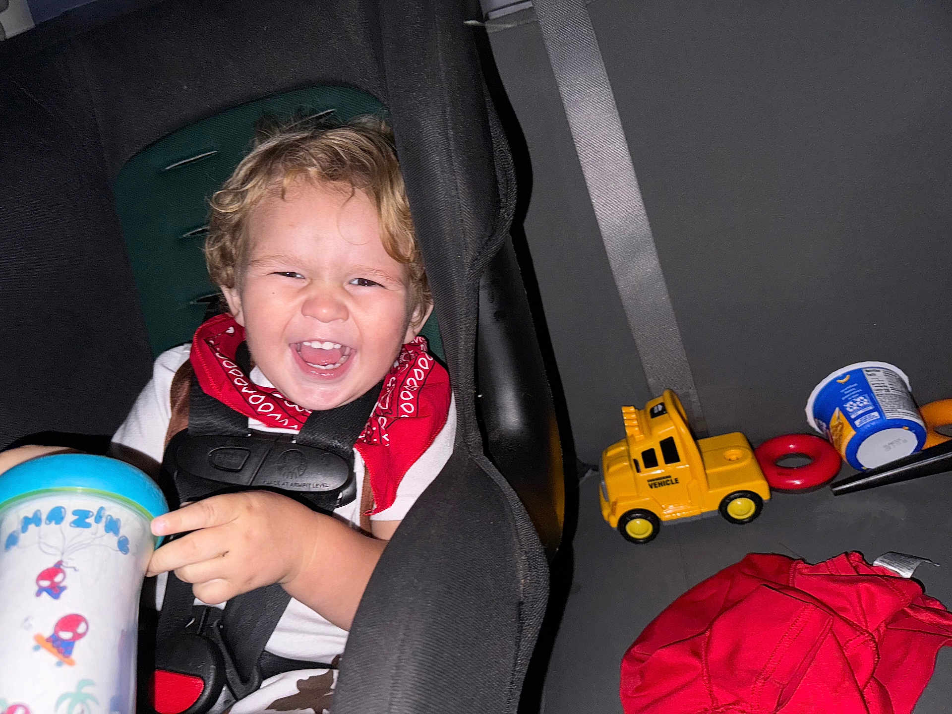 Bryson joined the competition — help win amazing prizes! toddler, child, car_seat, laughing, happy, red_bandana, toy_truck, cup, seatbelt, car_interior, child_safety, clothing, smile, young_child, plastic_toy, red_clothing, automobile, seat, infant, bright_colors