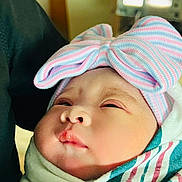 Ellie joined the competition — help win amazing prizes! baby, blanket, blue, cheeks, close_up, cozy, eyes, face, hat, indoor, infant, lips, newborn, nose, pastel, pink, portrait, sleepy, striped_hat, swaddle
