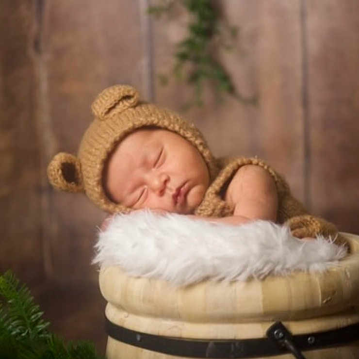 Ezio participe au concours pour gagner de l'argent avec cette photo : baby, bathing, blanket, bonnet, clothing, face, funeral, hat, head, newborn, person, sleeping