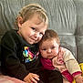 Paolina a rejoint le concours — aidez-le/la à gagner de superbes lots ! child, baby, couch, sitting, smile, face, clothing, pink, black_sweater, butterfly, indoor, toddler, cuddling, happy, person, hair, skin, comfort, family, cute