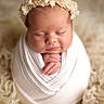 Tiffani participe au concours pour gagner de l'argent avec cette photo : newborn, baby, sleeping, wrapped, blanket, headband, flower_crown, soft_texture, cozy, infant, portrait, cute, peaceful, hands, closeup, warm_colors, studio_photo, child, resting, fluffy_rug