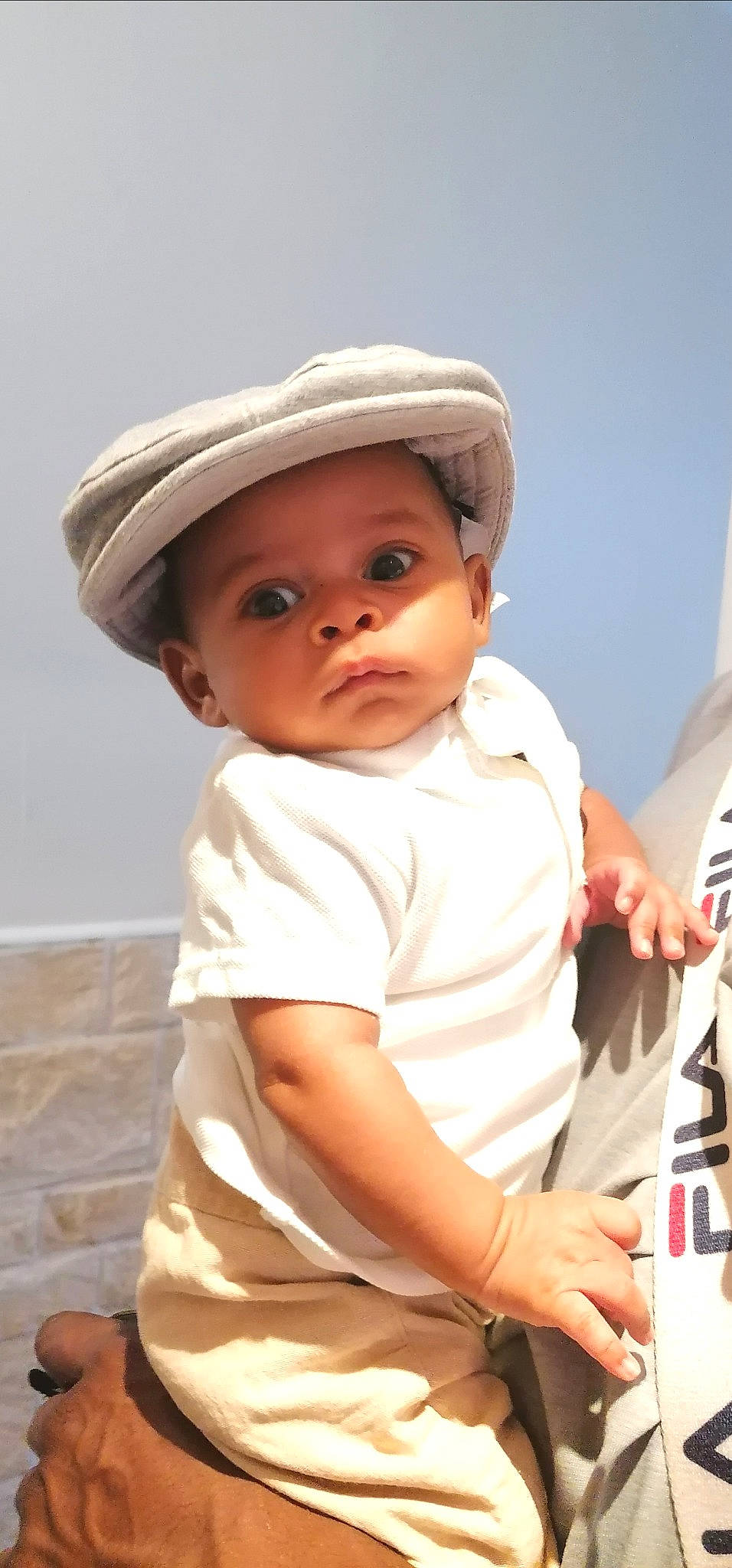 Youri a rejoint le concours — aidez-le/la à gagner de superbes lots ! baby, baby_toddler_clothing, cap, carmine, cheek, child, comfort, elbow, fashion_accessory, fun, gesture, happy, hat, headwear, lip, person, portrait_photography, sitting, sleeve, t_shirt