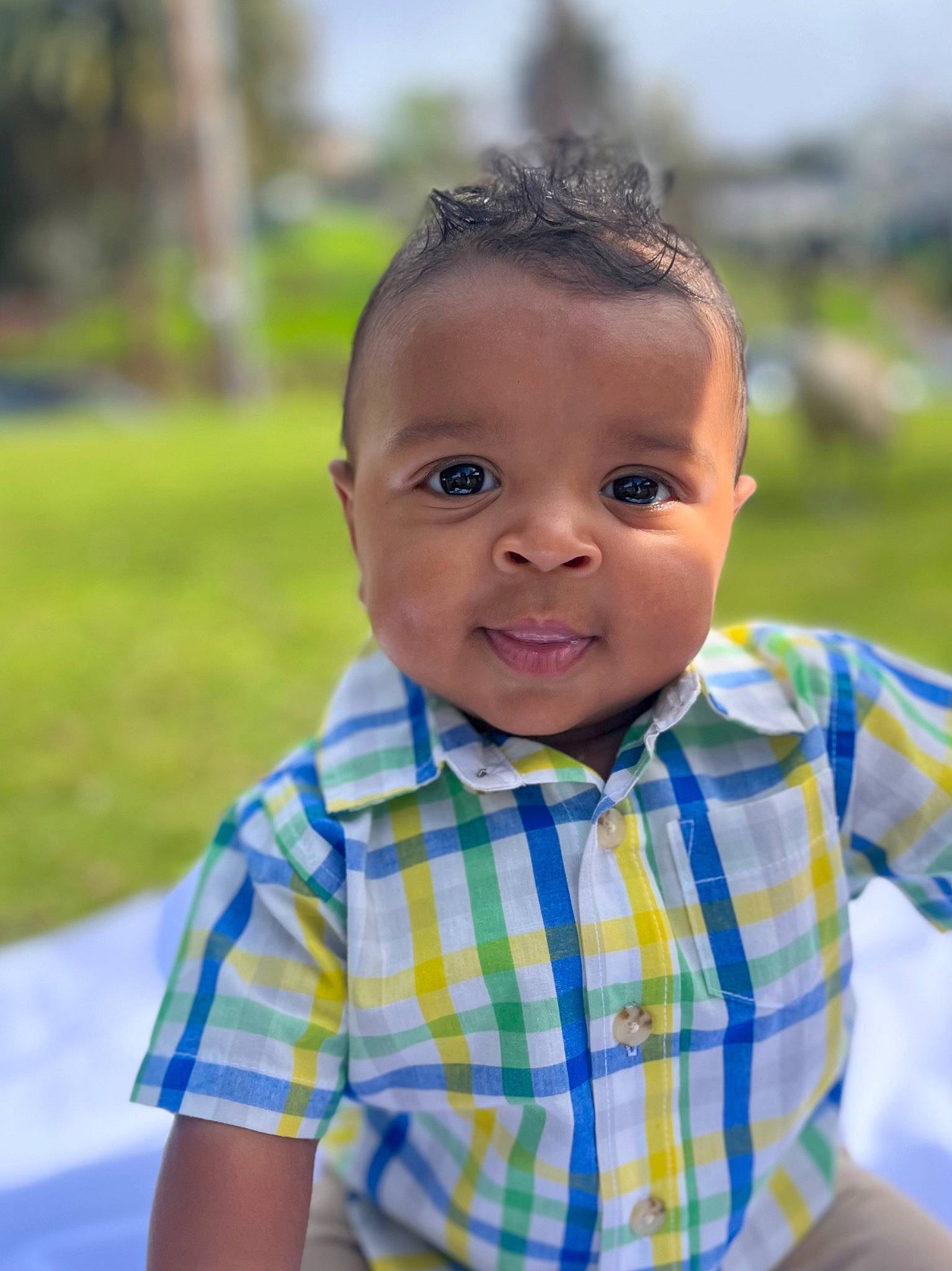 Jelani is registered to the contest to win money with this photo: baby, baby_toddler_clothing, child, eye, face, grass, happy, human_body, iris, leisure, lip, pattern, people_in_nature, person, plaid, plant, skin, sleeve, smile, tartan