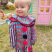 Noah joined the competition — help win amazing prizes! casual, child, clown_costume, colorful_clothing, costume, daylight, face, fall_leaves, grass, happy, headband, nature, outdoor, person, playground, playhouse, red_bow, smiling, toddler, toy