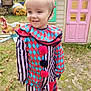 casual, child, clown_costume, colorful_clothing, costume, daylight, face, fall_leaves, grass, happy, headband, nature, outdoor, person, playground, playhouse, red_bow, smiling, toddler, toy
