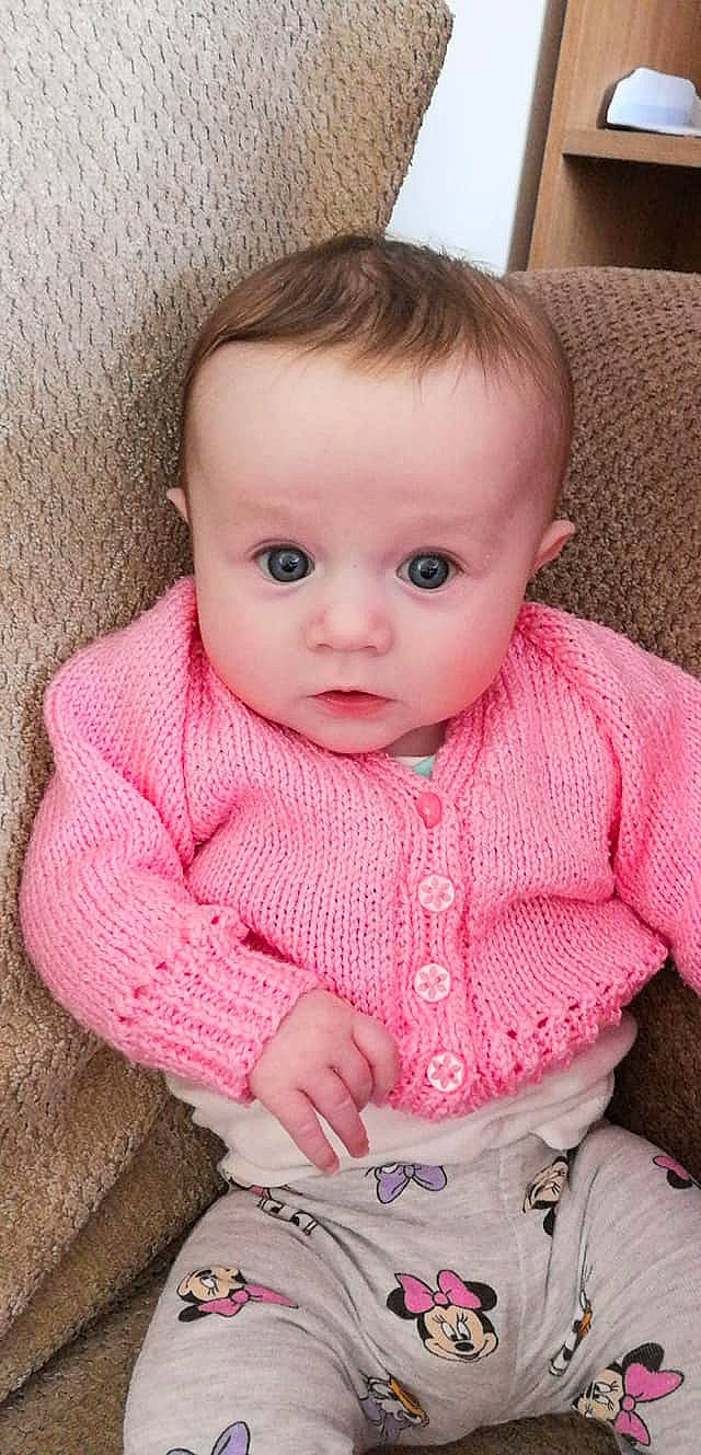 Abbey is registered to the contest to win money with this photo: baby, baby_toddler_clothing, beauty, cheek, child, eye, face, head, iris, knitting, lip, nose, outerwear, person, pink, sitting, skin, smile, sweater, toddler