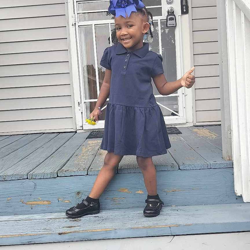 Zuri is registered to the contest to win money with this photo: architecture, building, child, clothing, door, dress, face, female, footwear, girl, hat, head, house, housing, people, person, photography, porch, portrait, shoe