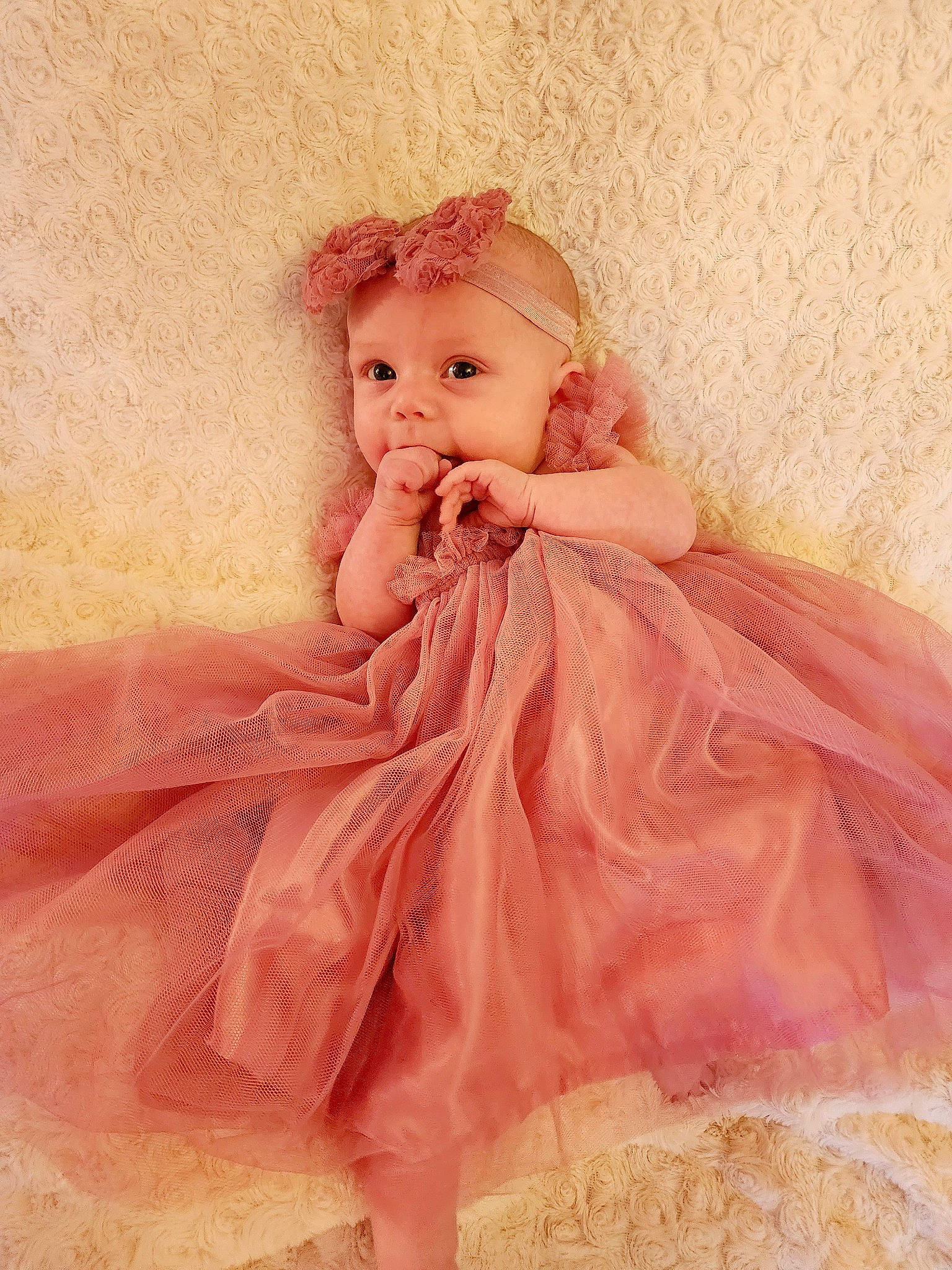 Evelyn is registered to the contest to win money with this photo: art, baby_toddler_clothing, bridal_accessory, brown_hair, child, day_dress, dress, embellishment, fashion_accessory, fashion_design, headwear, iris, one_piece_garment, pattern, peach, person, pink, ruffle, sitting, sleeve