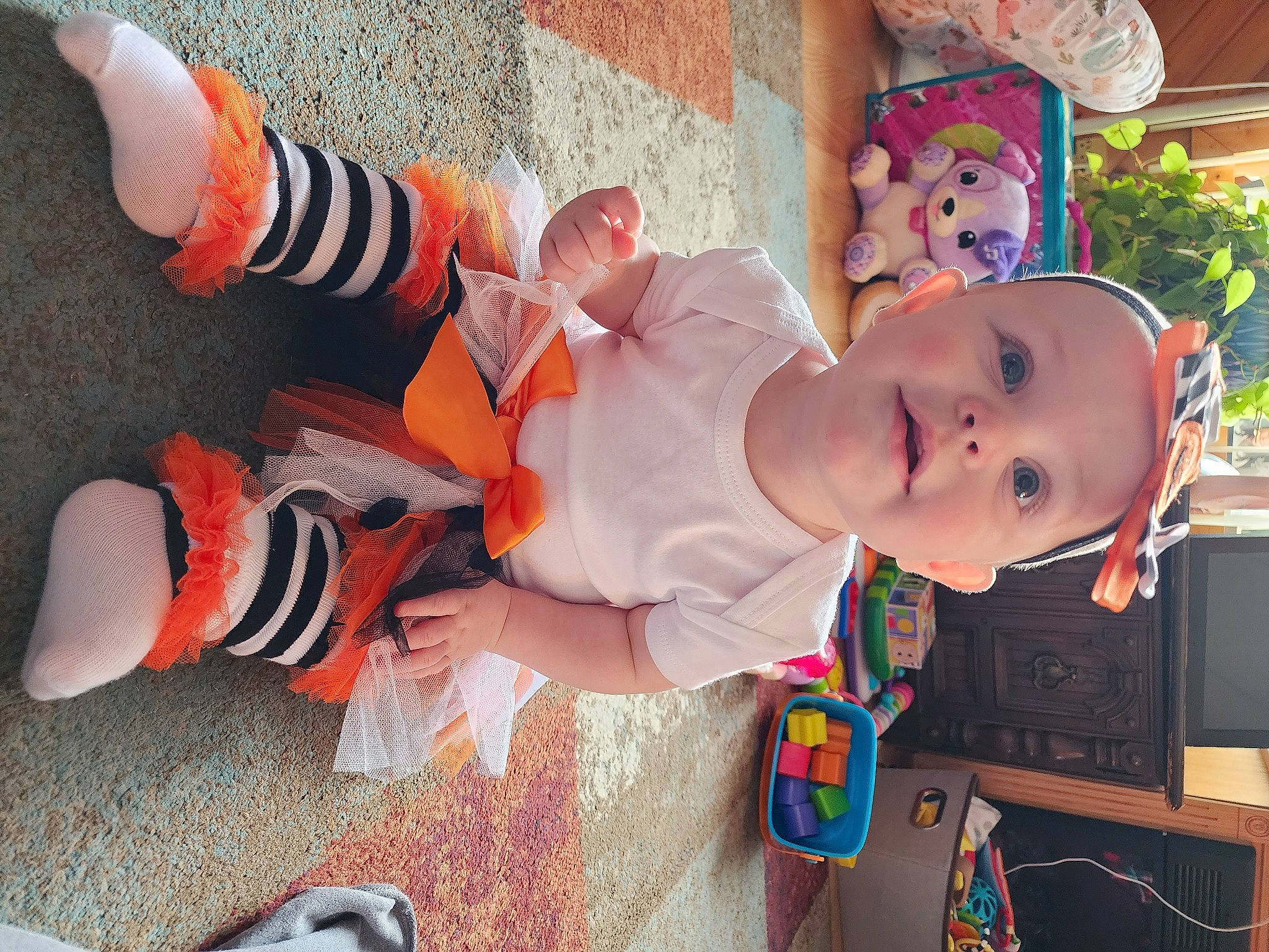 Evelyn is registered to the contest to win money with this photo: baby, baby_products, baby_toddler_clothing, child, dress, flowerpot, fun, glasses, happy, hat, human_leg, leg, orange, person, pink, plant, sandal, smile, sunglasses, thigh
