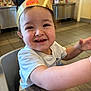 toddler, child, smile, burger_king, crown, fast_food, restaurant, table, white_shirt, happy, face, curly_hair, indoor, high_chair, arm, expression, food_court, background, person, closeup