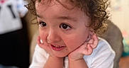 Luka joined the competition — help win amazing prizes! toddler, child, curly_hair, white_shirt, highchair, indoor, face, hands, expression, cute, portrait, smiling, young_child, person, looking_away, skin, eyes, mouth, hair, sitting