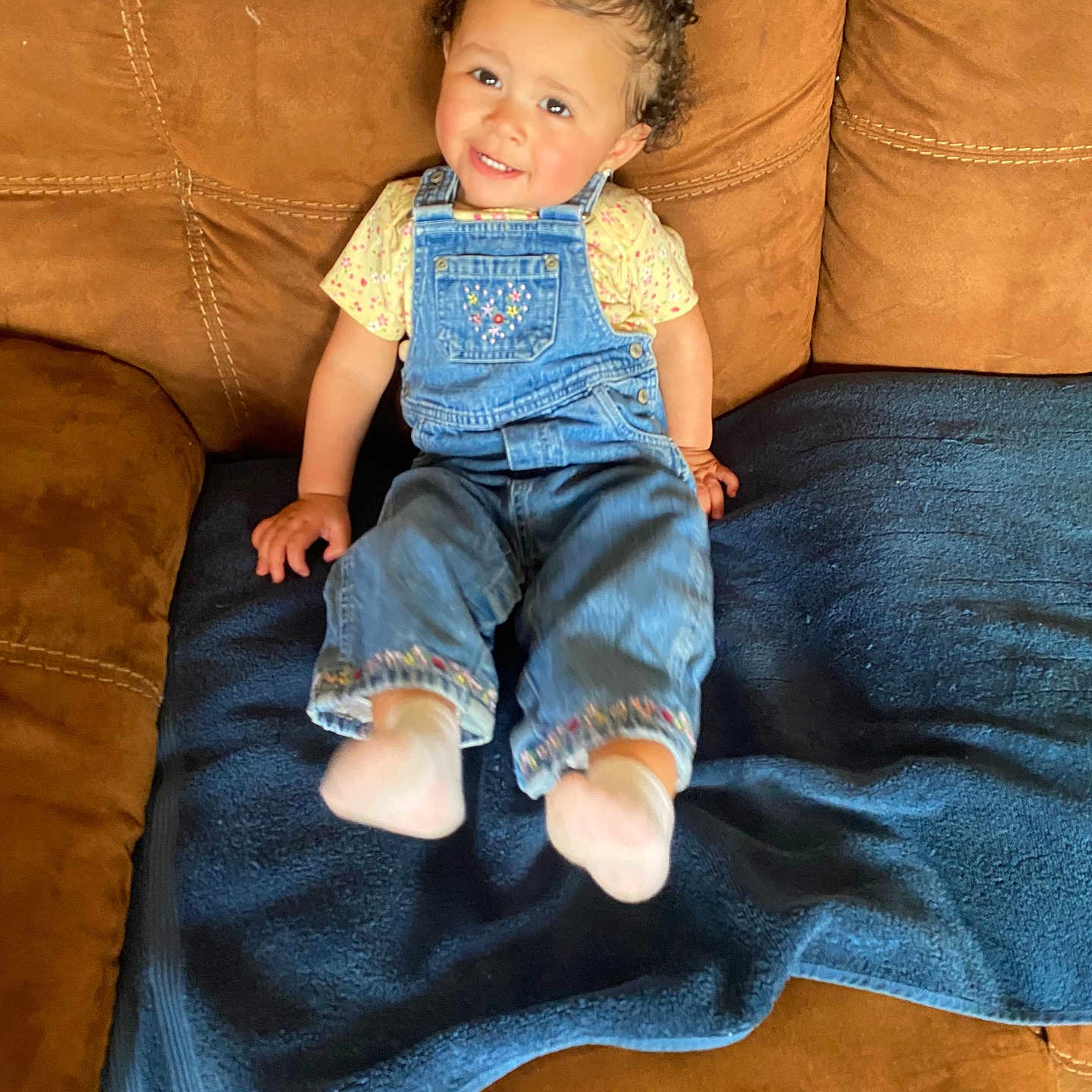 Stormee joined the competition — help win amazing prizes! baby, blanket, casual, child, clothing, couch, cute, denim_overalls, face, furniture, hair_clips, happy, home, indoor, person, pigtails, portrait, sitting, smiling, toddler