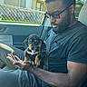 Scooby-Doo joined the competition — help win amazing prizes! man, puppy, dog, car_interior, seatbelt, glasses, black_shirt, hand, window, fence, house, sunlight, beard, short_hair, sitting, pet, cute, domestic_animal, portrait, daytime