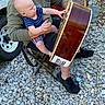 Rhett joined the competition — help win amazing prizes! baby, blue_shirt, camouflage_cap, casual, daylight, folding_chair, footwear, gravel, guitar, instrument, man, music, nature, outdoor, person, plaid_shorts, playing, reaching, trailer, wheel