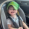 baby, child, infant, smiling, happy, car_seat, car, vehicle, green_cap, baseball_cap, john_deere, overalls, clothing, seat_belt, harness, portrait, indoor, sunlight, road_trip, automotive_interior