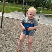 Rhett is registered to the contest to win money with this photo: baby, toddler, child, playground, swing, outdoor, park, sitting, sleepy, face, blond_hair, gray_clothing, sandals, summer, grass, trees, sidewalk, safety_seat, portrait, photography