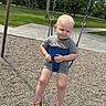 baby, toddler, child, playground, swing, outdoor, park, sitting, sleepy, face, blond_hair, gray_clothing, sandals, summer, grass, trees, sidewalk, safety_seat, portrait, photography