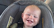 Rhett joined the competition — help win amazing prizes! baby, child, infant, smiling, happy, portrait, car_seat, seatbelt, vehicle, car, dashboard, driver, road_trip, outdoor, daylight, face, green_shirt, safety_harness, sun_hat, family_travel