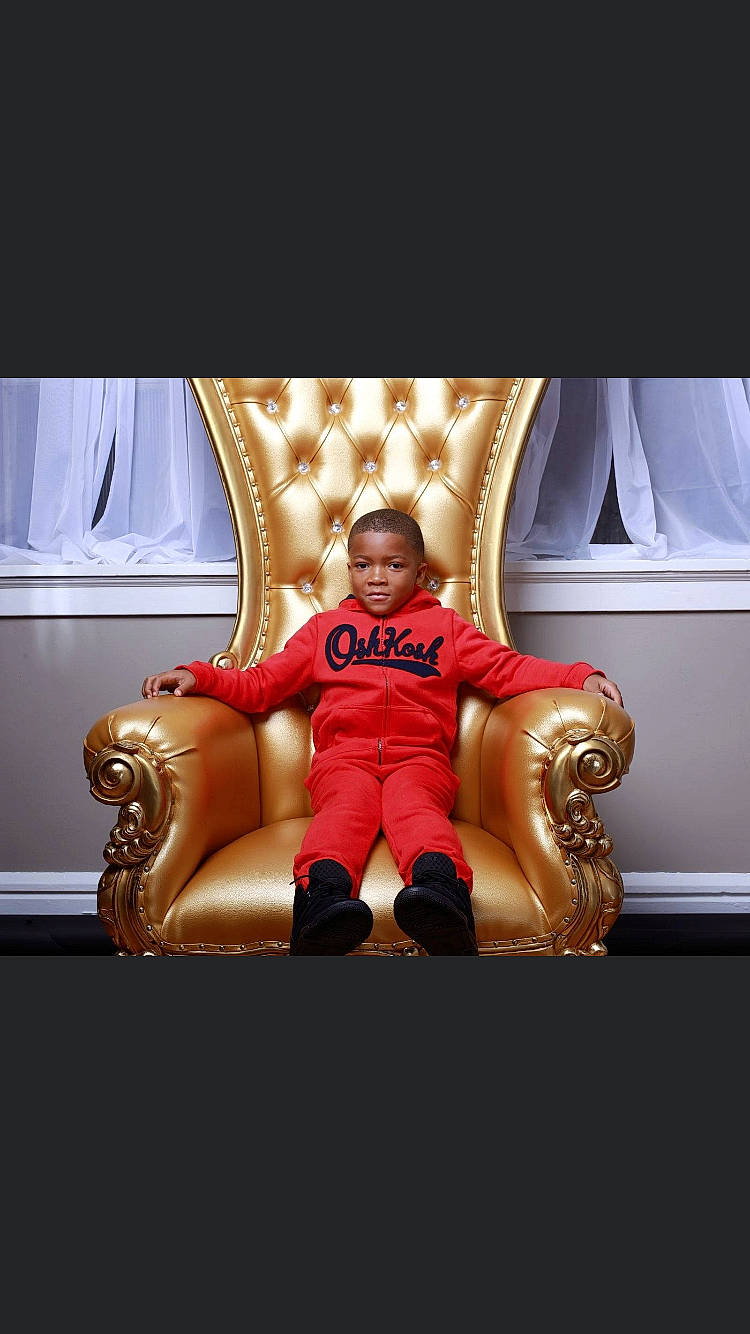 Jamarion is registered to the contest to win money with this photo: chair, child, couch, fictional_character, furniture, interior_design, person, photography, red, room, sitting, stock_photography, throne