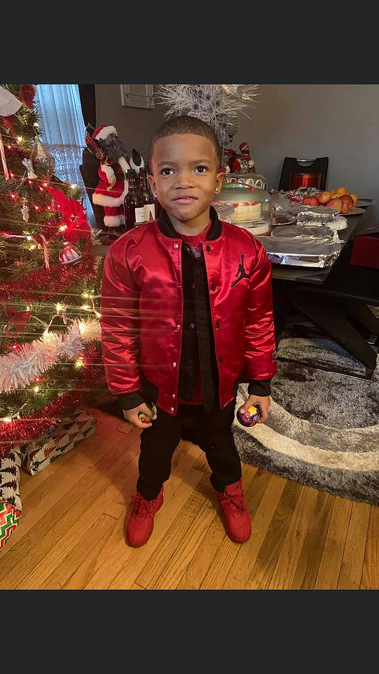 Jamarion joined the competition — help win amazing prizes! child, child_model, christmas, christmas_decoration, christmas_eve, christmas_tree, holiday, jacket, leather_jacket, outerwear, person, smile, standing, toddler