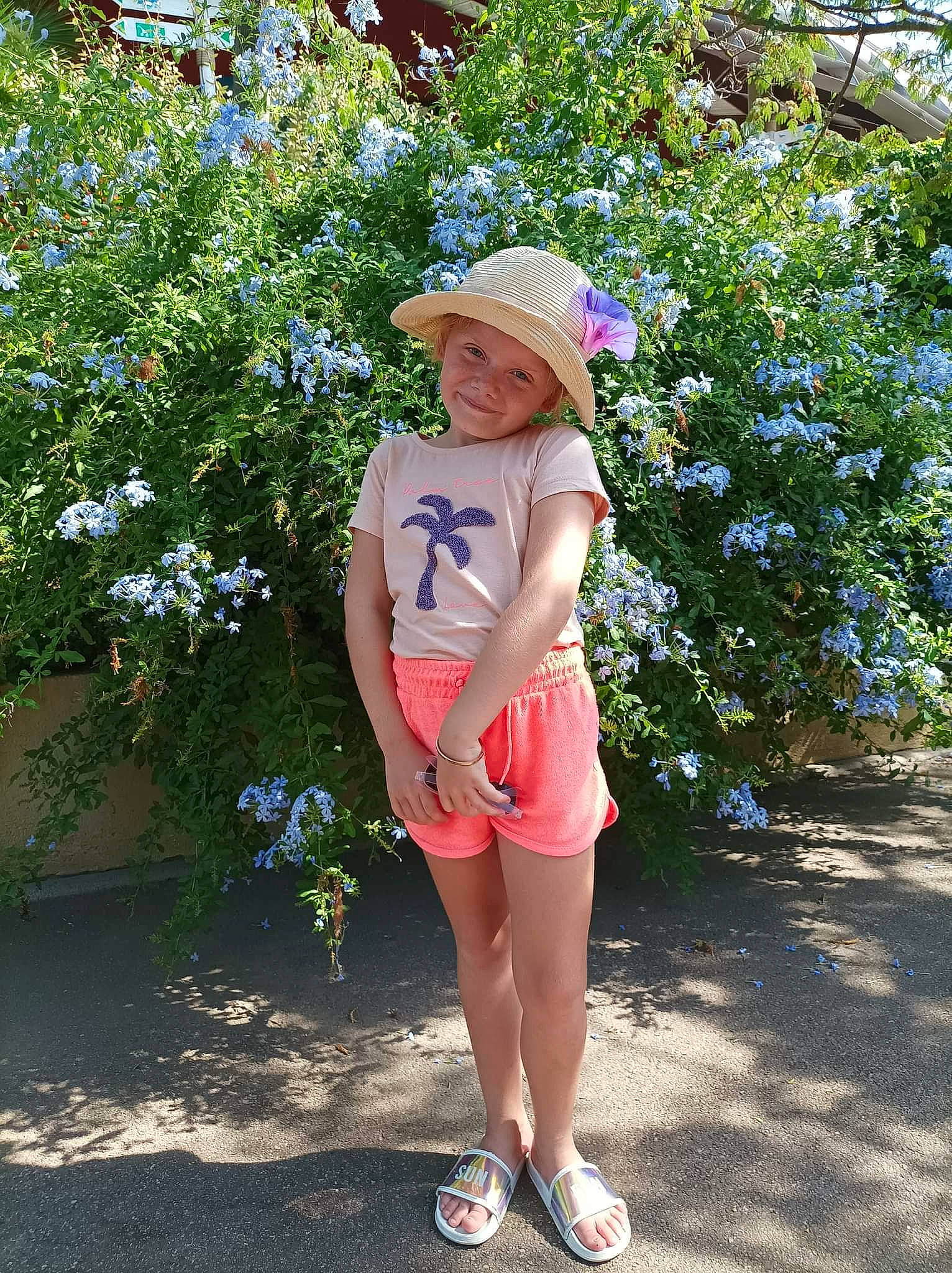 Émilie participe au concours pour gagner de l'argent avec cette photo : electric_blue, eyewear, fedora, flower, grass, happy, hat, headwear, human_leg, joy, knee, leisure, people_in_nature, person, plant, shoulder, sleeve, sun_hat, t_shirt, thigh