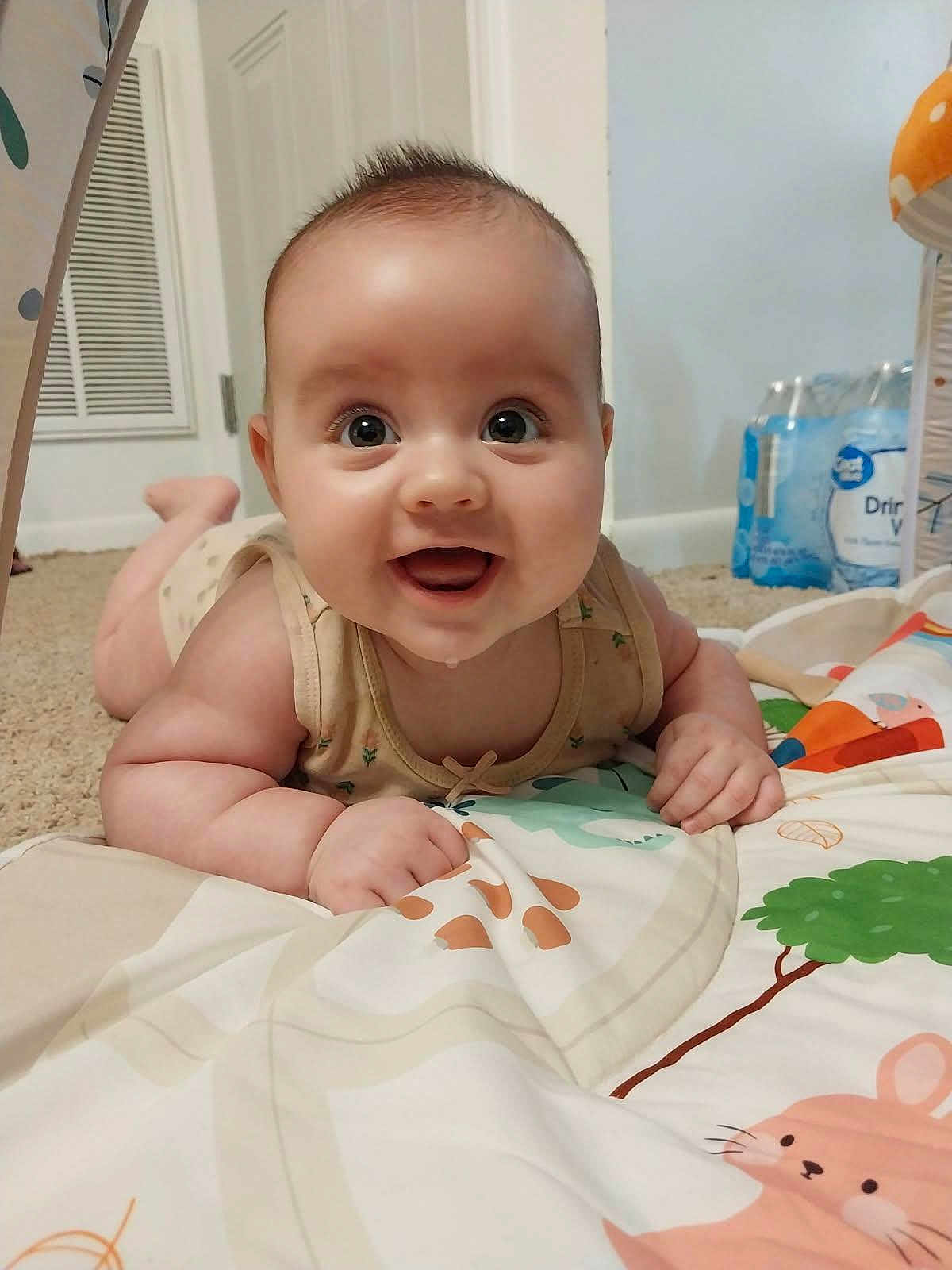Adora is registered to the contest to win money with this photo: baby, infant, smiling, happy, play_mat, indoor, child, cute, chubby, face, person, carpet, clothing, hand, head, eyes, mouth, skin, toy, home