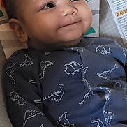 Jules a rejoint le concours — aidez-le/la à gagner de superbes lots ! baby, infant, child, dinosaur_onesie, baby_seat, hand, face, eyes, smile, cute, indoor, toy, monkey, sun, colorful, comfort, clothing, portrait, person, relaxing