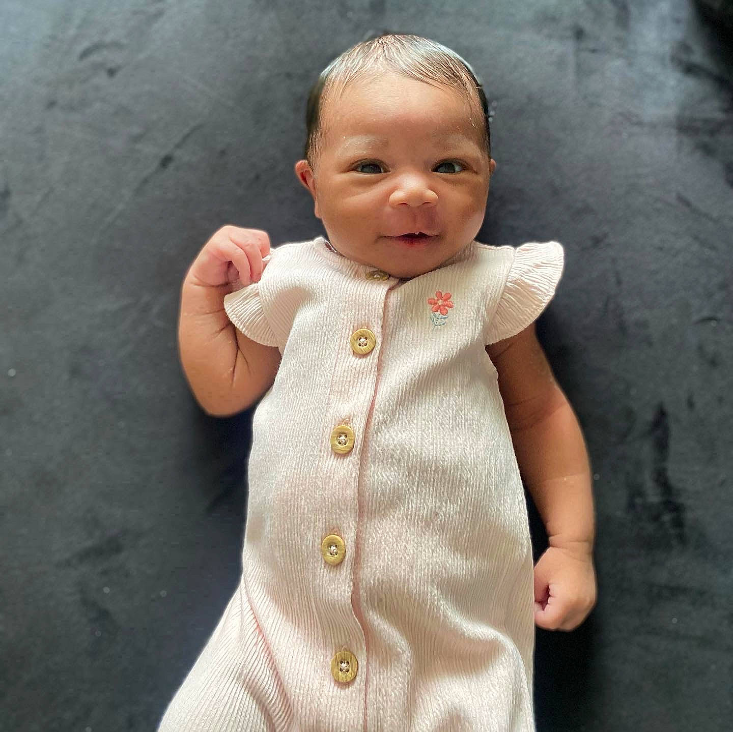 Amaya Brielle is registered to the contest to win money with this photo: baby, baby_toddler_clothing, button, cheek, child, collar, dress, face, gesture, happy, lip, neck, nose, pattern, person, skin, sleeve, standing, t_shirt, thumb