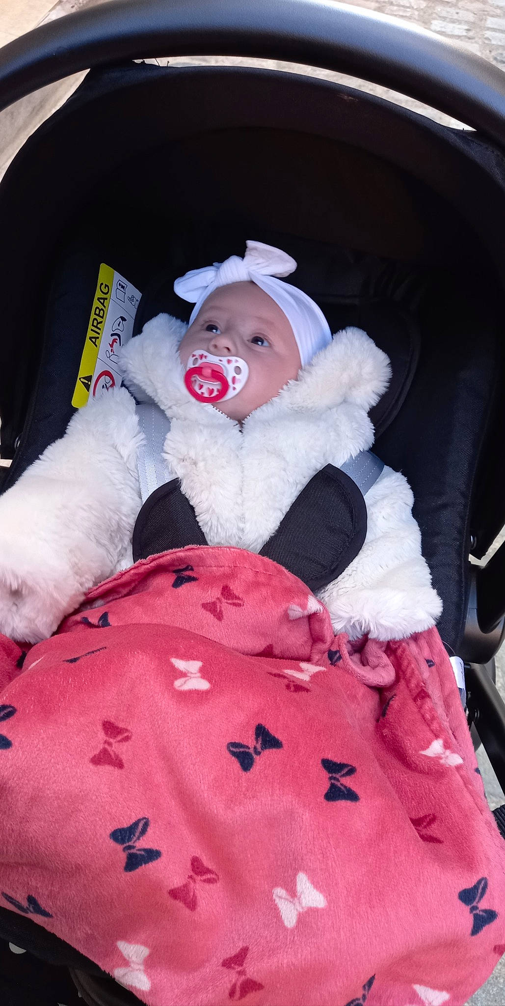 Sofia a rejoint le concours — aidez-le/la à gagner de superbes lots ! auto_part, baby, baby_products, baby_toddler_clothing, car_seat, car_seat_cover, carmine, comfort, family_car, fur, hat, headwear, lap, linens, person, pink, seat_belt, sitting, stuffed_toy, toddler