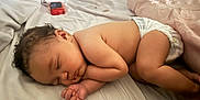 Zariah is registered to the contest to win money with this photo: baby, bed, bedroom, blanket, bodypart, diaper, electronics, face, finger, furniture, hand, head, indoors, mobilephone, newborn, person, phone, photography, portrait, sleeping