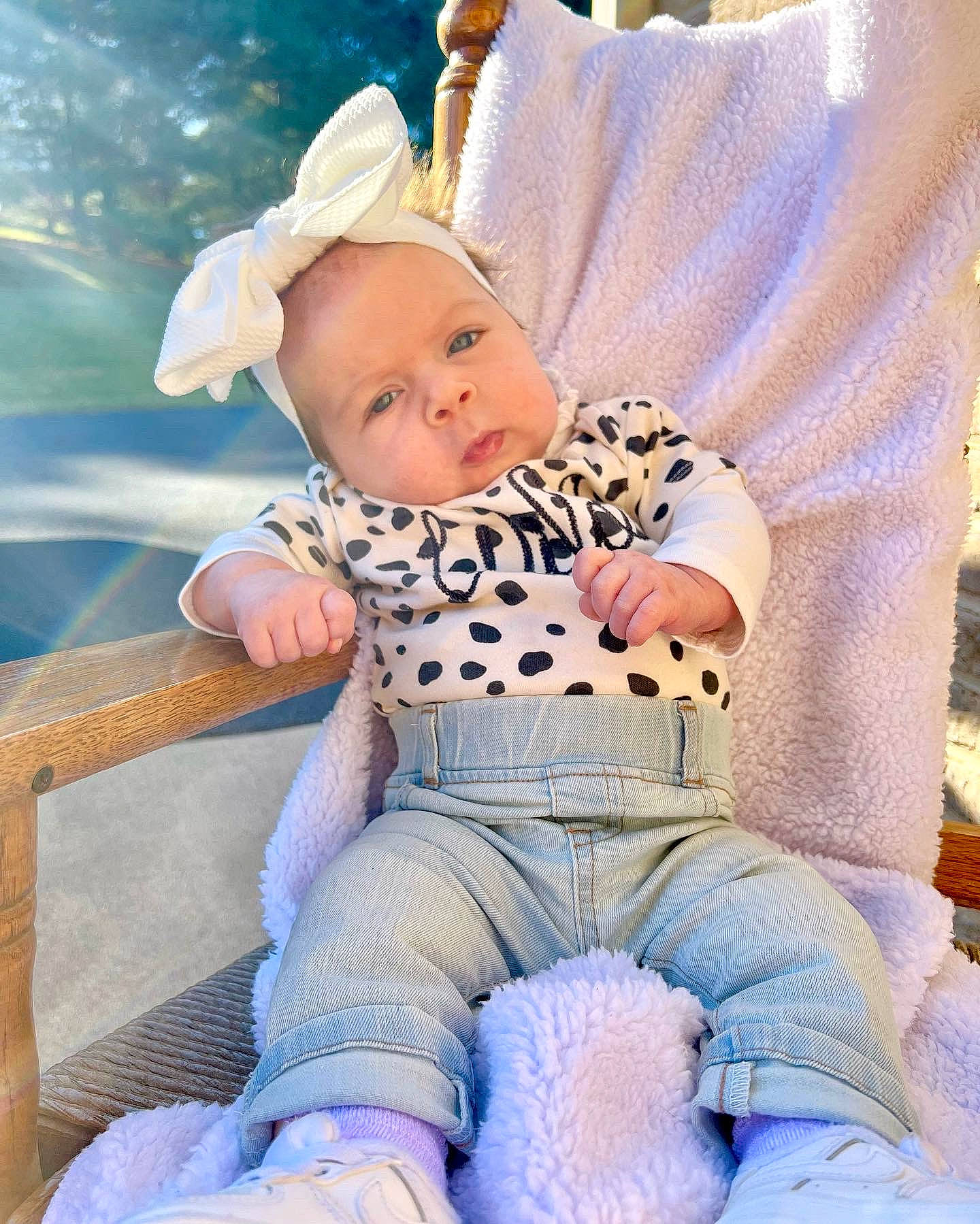 Lilianna is registered to the contest to win money with this photo: baby, baby_products, baby_toddler_clothing, chair, cheek, child, electric_blue, eye, fun, grass, happy, hat, lap, pattern, person, portrait_photography, purple, sitting, skin, sleeve