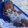 baby, pacifier, beach_chair, striped, onesie, animal_print, towel, sand, outdoor, relaxing, child, infant, sleepy, cute, clothing, summer, vacation, comfort, resting, person