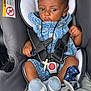 baby, car_seat, infant, blue_outfit, pacifier, sock, seatbelt, warning_label, child, straps, cute, indoor, sitting, head, person, clothing, portrait, accessory, baby_accessory, curly_hair