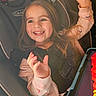 child, car_seat, smiling, happy, girl, long_hair, tablet, technology, seatbelt, clothing, jacket, indoor, closeup, person, seat, car_interior, bright, expression, young, hands_up