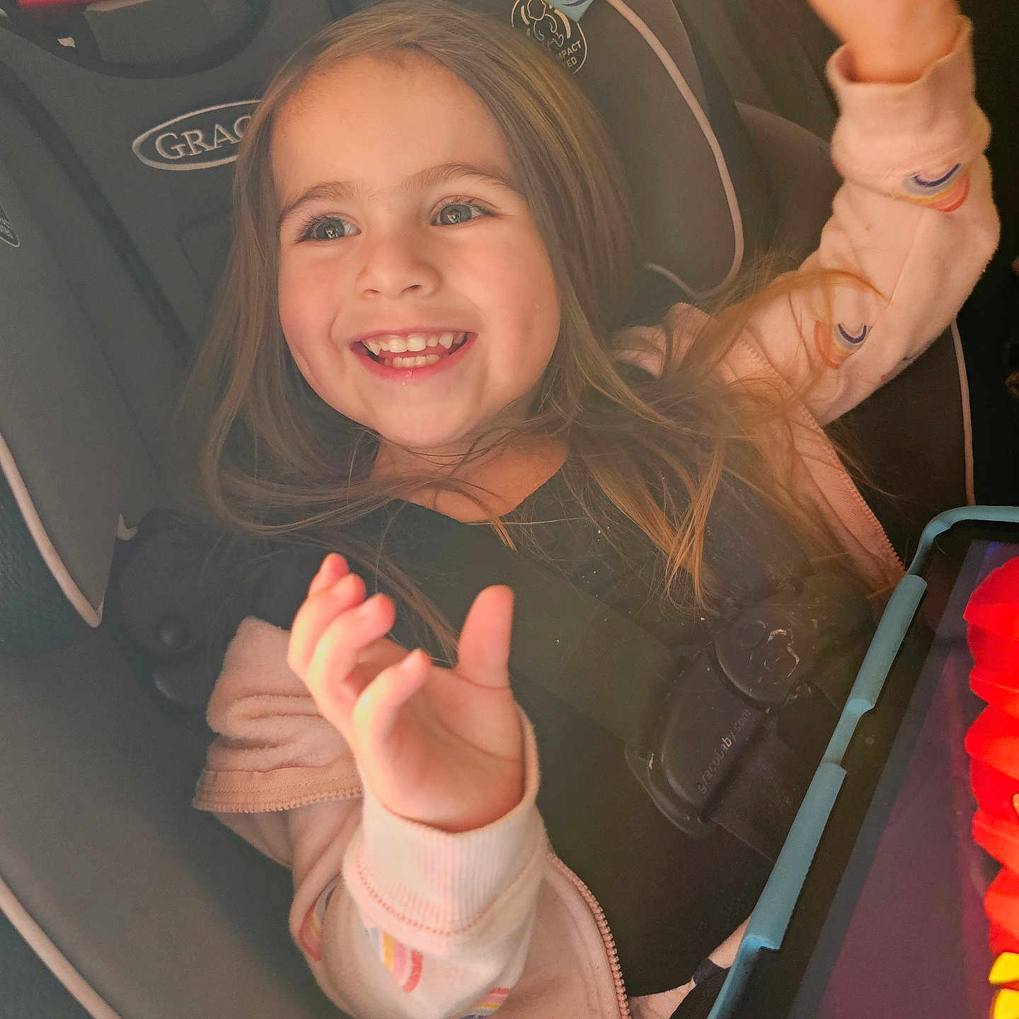 Niyah joined the competition — help win amazing prizes! child, car_seat, smiling, happy, girl, long_hair, tablet, technology, seatbelt, clothing, jacket, indoor, closeup, person, seat, car_interior, bright, expression, young, hands_up