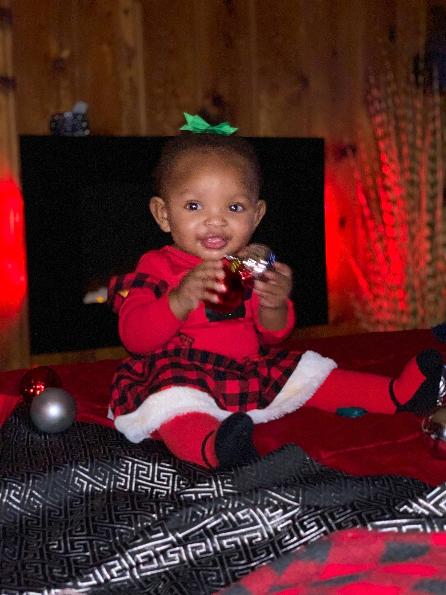 Jhené joined the competition — help win amazing prizes! baby, baby_toddler_clothing, carpet, child, christmas, curtain, linens, person, red, room, sock, toddler