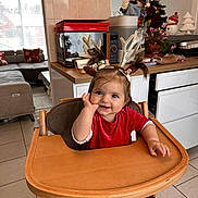 Clara participe au concours pour gagner de l'argent avec cette photo : baby, child, high_chair, red_clothing, reindeer_antlers, pigtails, kitchen, christmas_tree, holiday_decorations, smile, festive, indoor, wooden_furniture, cute, happy, person, face, table, tile_floor, home
