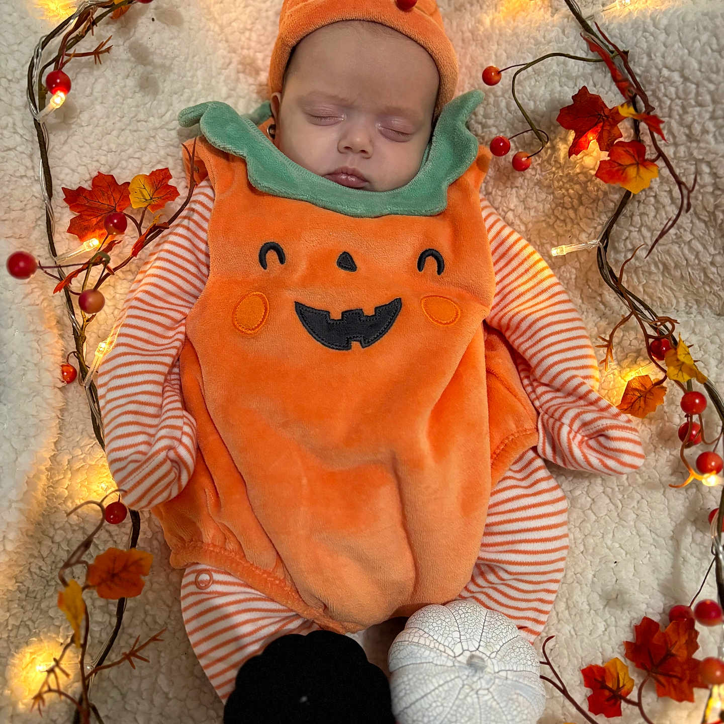 Arabella is registered to the contest to win money with this photo: autumn, baby, black, blanket, child, cozy, cute, decorative_leaves, fairy_lights, festive, holiday, holiday_decoration, infant, orange, portrait, pumpkin_costume, seasonal, sleeping, soft, white