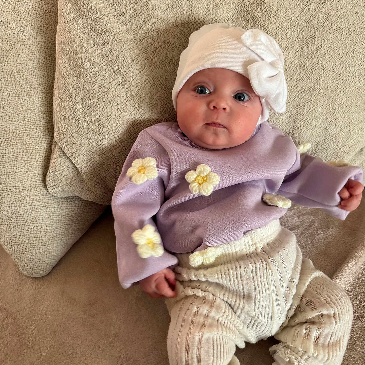 Alba participe au concours pour gagner de l'argent avec cette photo : baby, blanket, bodypart, bonnet, cap, clothing, couch, face, finger, furniture, hand, hat, head, hood, newborn, pants, person, photography, portrait, sitting