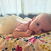 Olivia joined the competition — help win amazing prizes! baby, infant, tutu, fairy_wings, blanket, floral_pattern, blue_eyes, cute, soft_light, window, bedroom, lying_down, pink_clothing, hand, face, portrait, indoor, child, curious, closeup