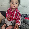Cameron is registered to the contest to win money with this photo: barefoot, big_eyes, blanket, casual, child, concrete_wall, cozy, curious, curly_hair, expression, feet, indoor, pants, person, plaid_shirt, portrait, red_shirt, sitting, toddler, young_child